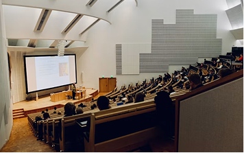 A lecture theatre with a presentation displayed on screen