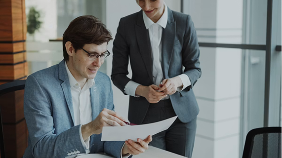 Manager and employee reviewing a printed record together